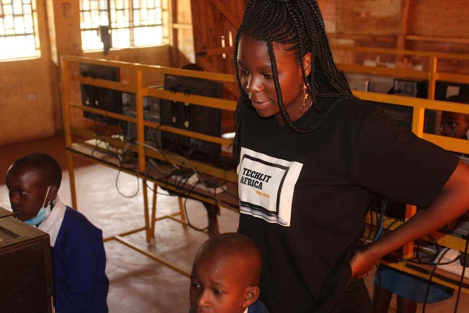 Milka Akware supervising a computer classroom