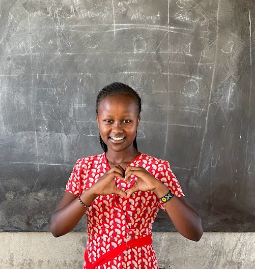 Portrait of Lucy Koi in a red dress doing a heart pose